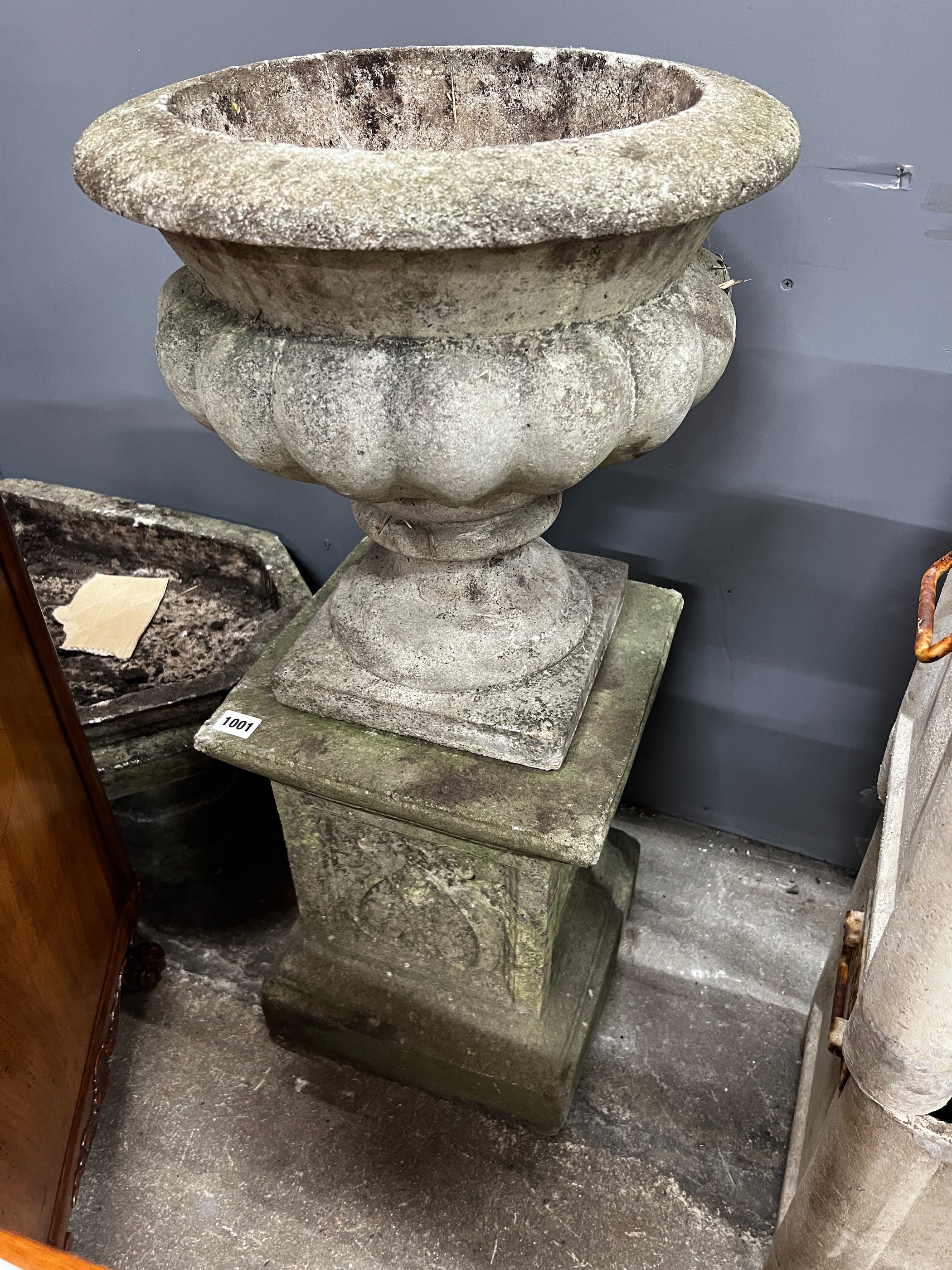 A circular reconstituted stone garden planter on square plinth, diameter 40cm, height 84cm together with an octagonal shallow stone planter, width 62cm, height 33cm
